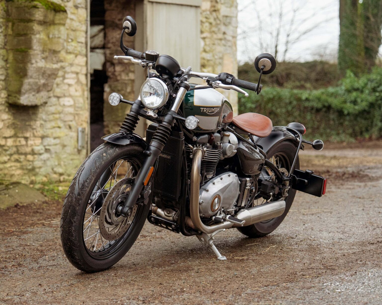 Triumph vintage motorcycle on rustic outdoor background.