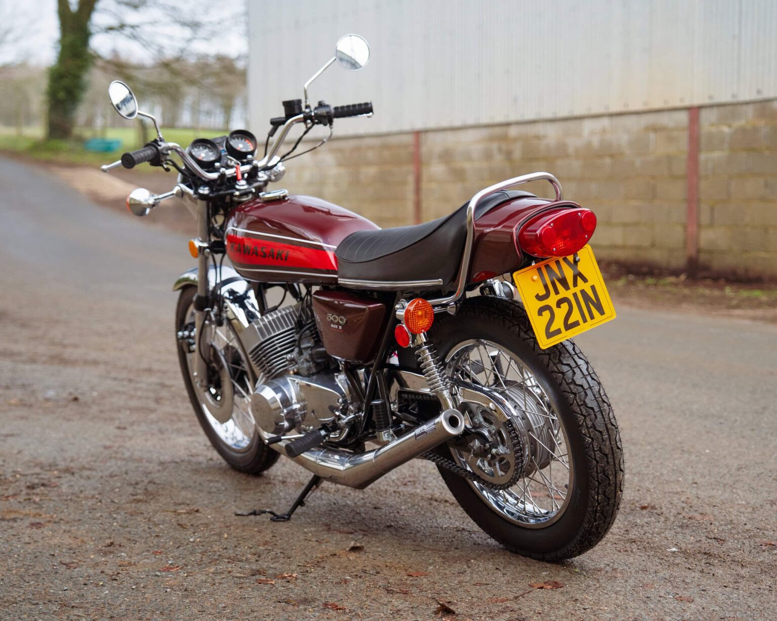 Vintage Kawasaki motorcycle parked on a rural road.