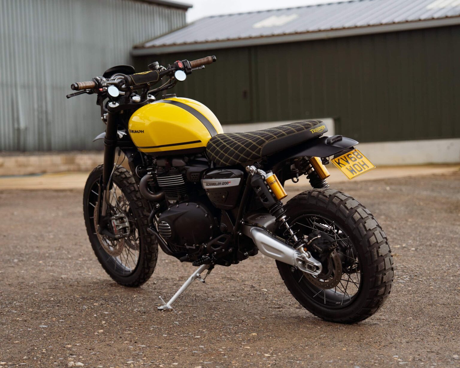 Yellow custom motorcycle with rugged tires and vintage style.