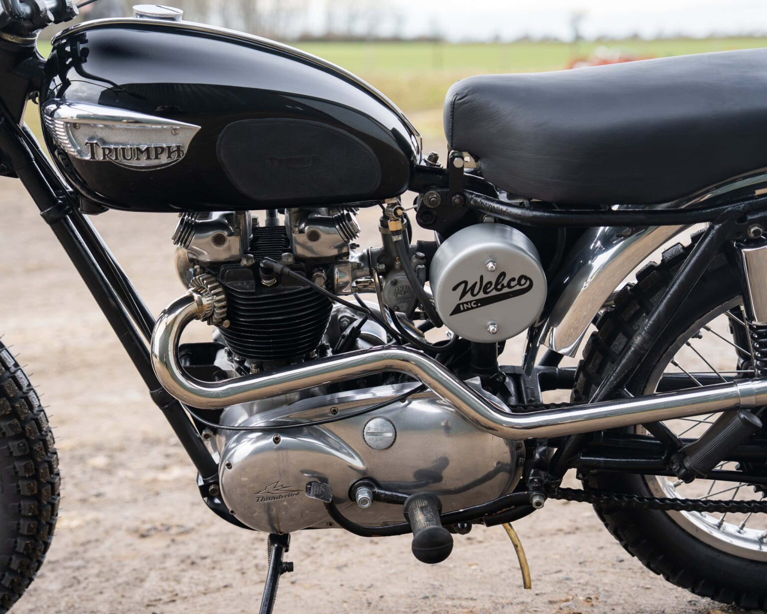 Triumph vintage motorcycle with black fuel tank and chrome engine parts.