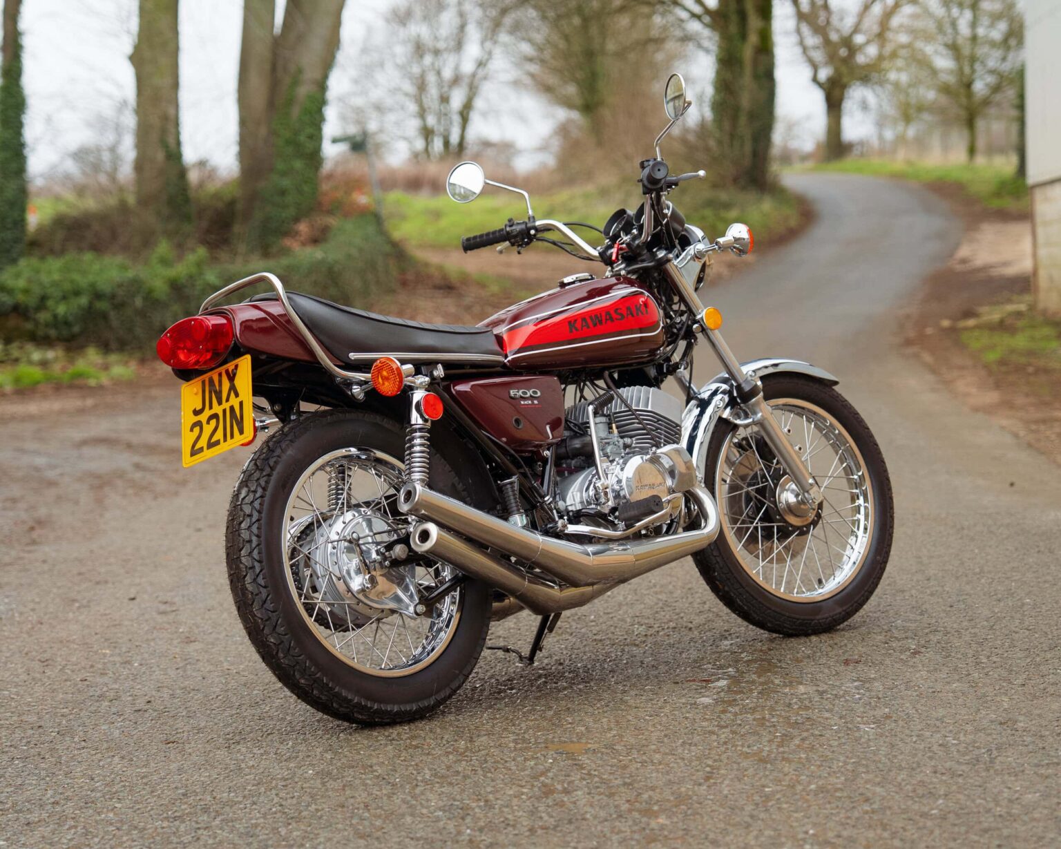 Kawasaki vintage motorcycle parked on a rural road.