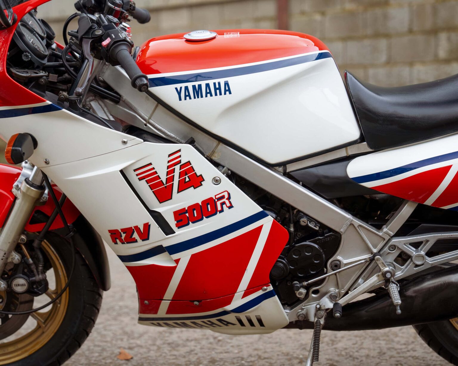 Vintage Yamaha RZV500R racing motorcycle with iconic red, white, and blue livery.