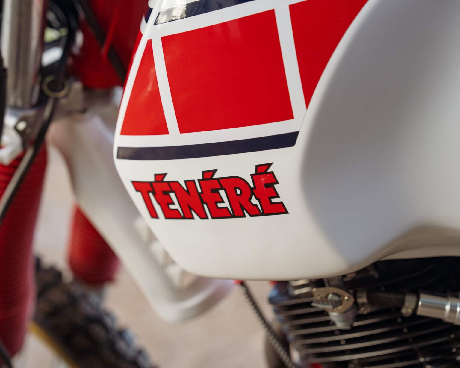 Close-up of a Ténéré motorcycle fuel tank with red and white design.
