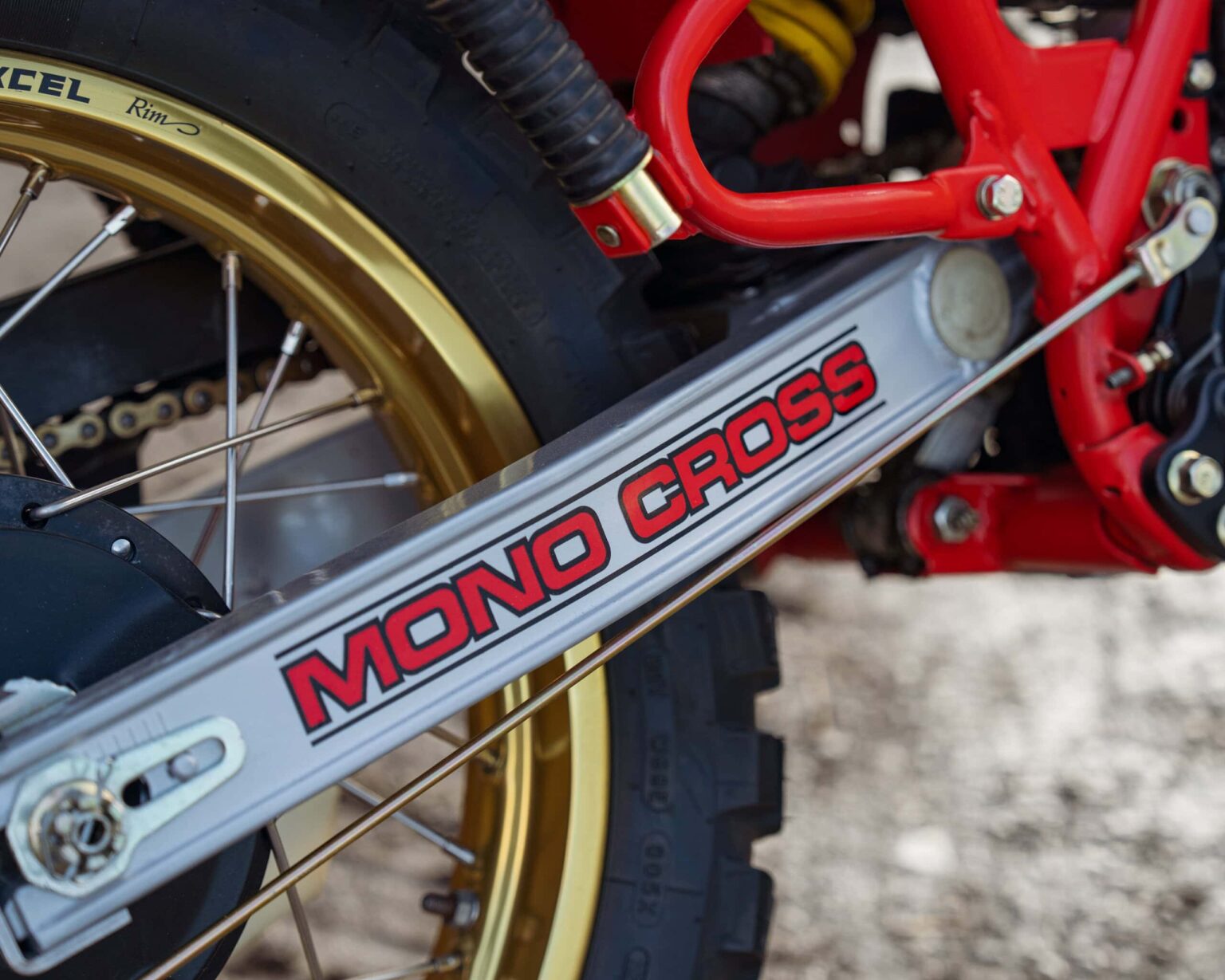 Up of Mono Cross suspension on a dirt bike with gold wheel rim.