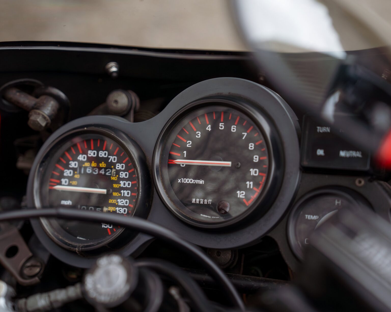 Motorcycle dashboard displaying speed and engine RPM gauges.