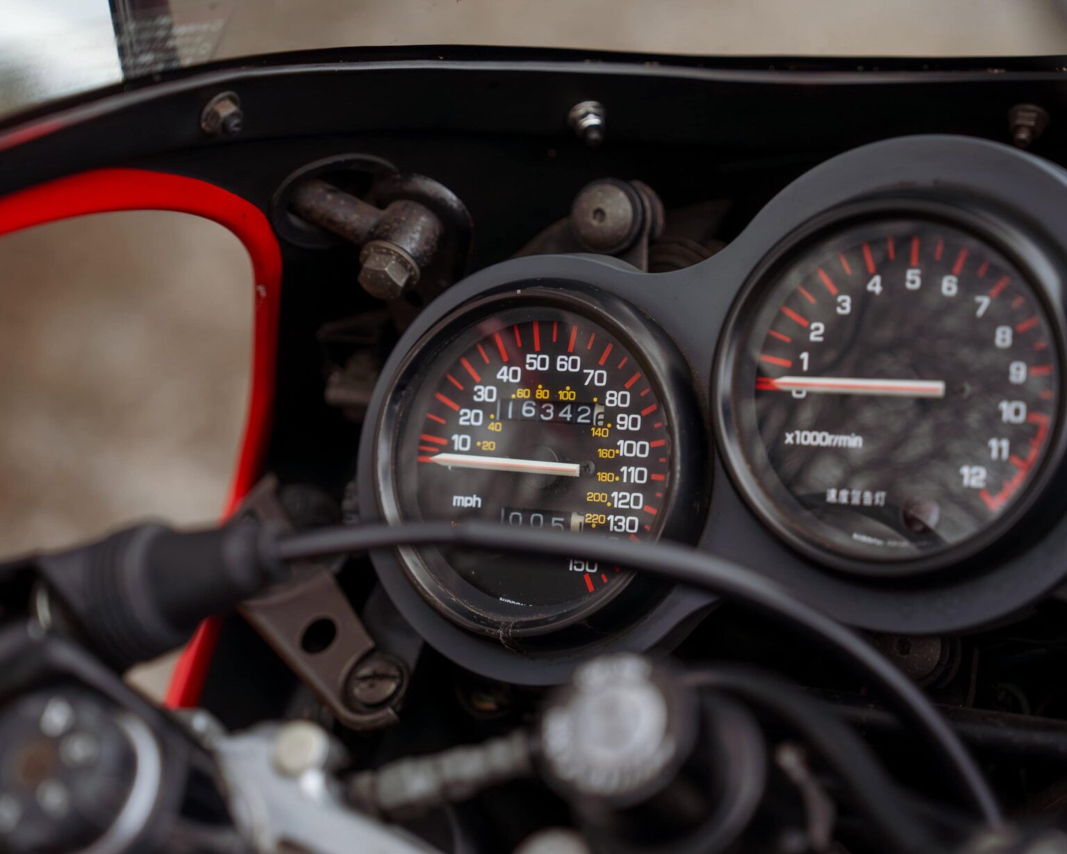 Motorcycle speedometer and tachometer gauges showing speed and engine RPM.