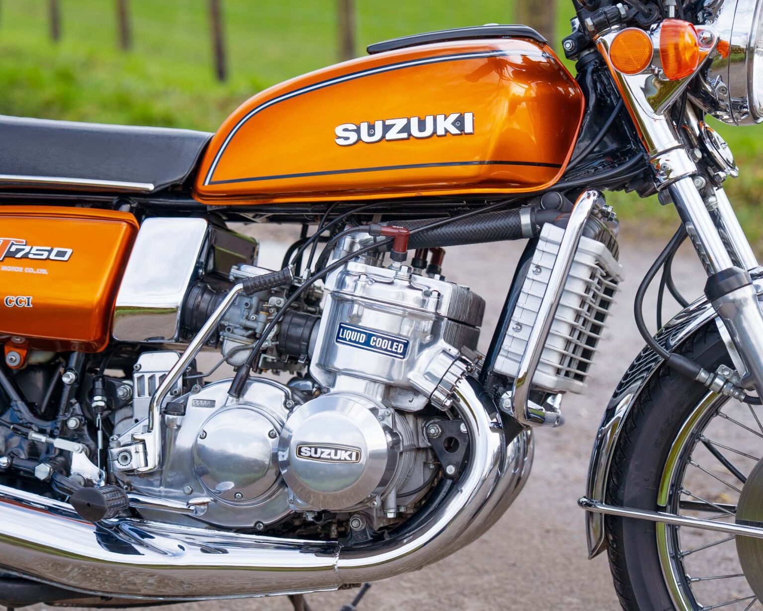 Vintage Suzuki motorcycle with orange fuel tank and chrome engine.
