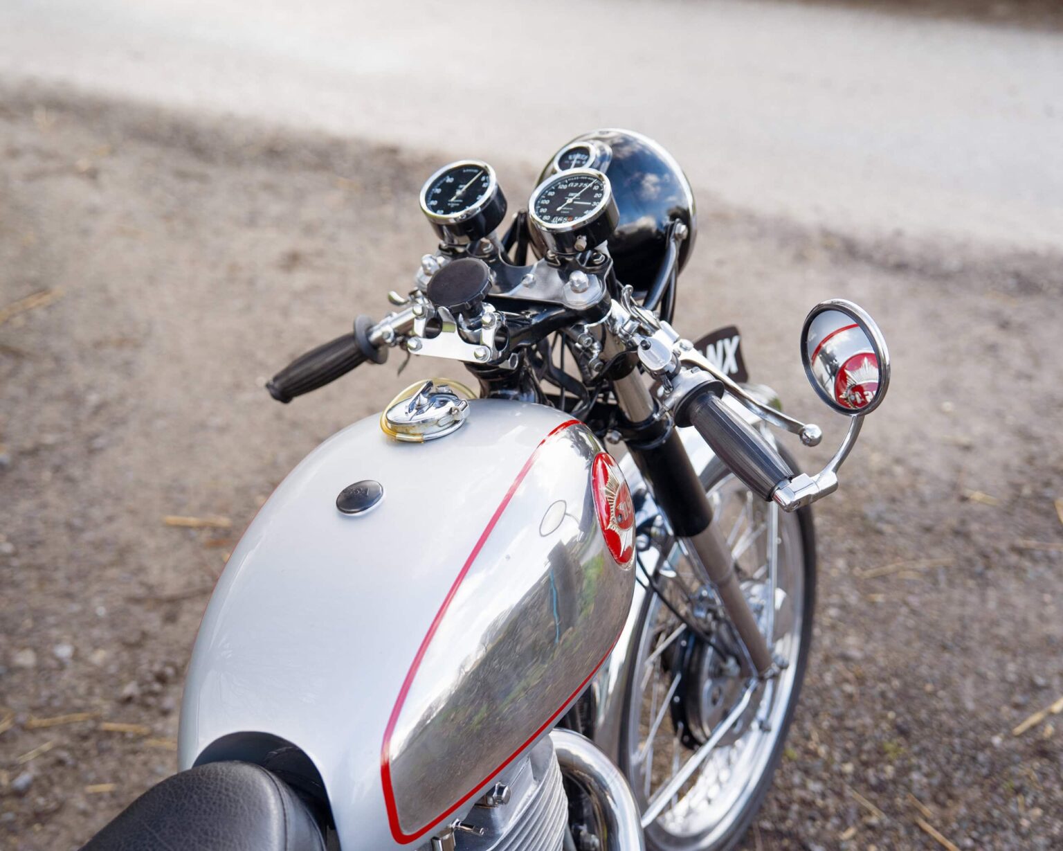 Vintage motorcycle dashboard with speedometer and handlebar details.