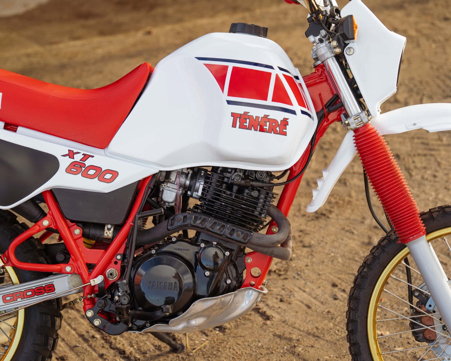 Classic Ténéré XT 600 motorcycle with red and white design on dirt track.