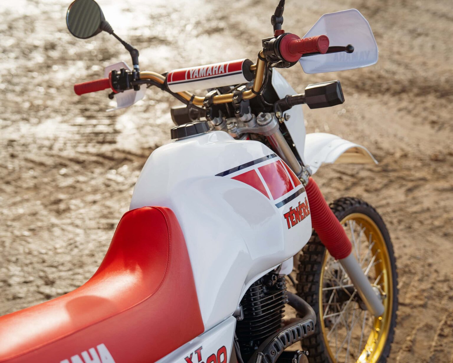 Yamaha dirt bike with red and white colour scheme and gold wheels on dirt track.