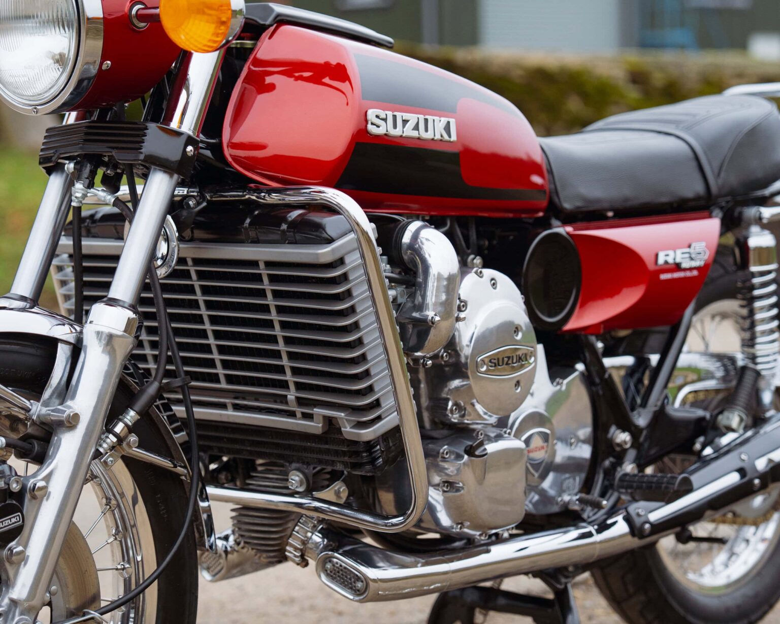 Vintage Suzuki motorcycle with red and black paintwork and chrome details.
