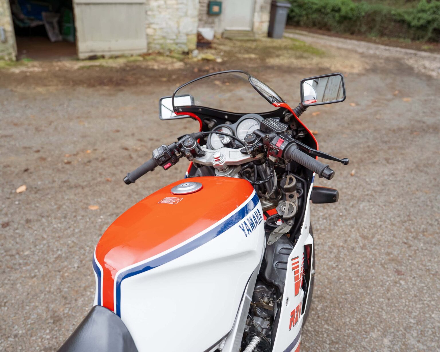 Yamaha racing motorcycle with orange, white, and blue livery, designed for classic motorcycle compet.