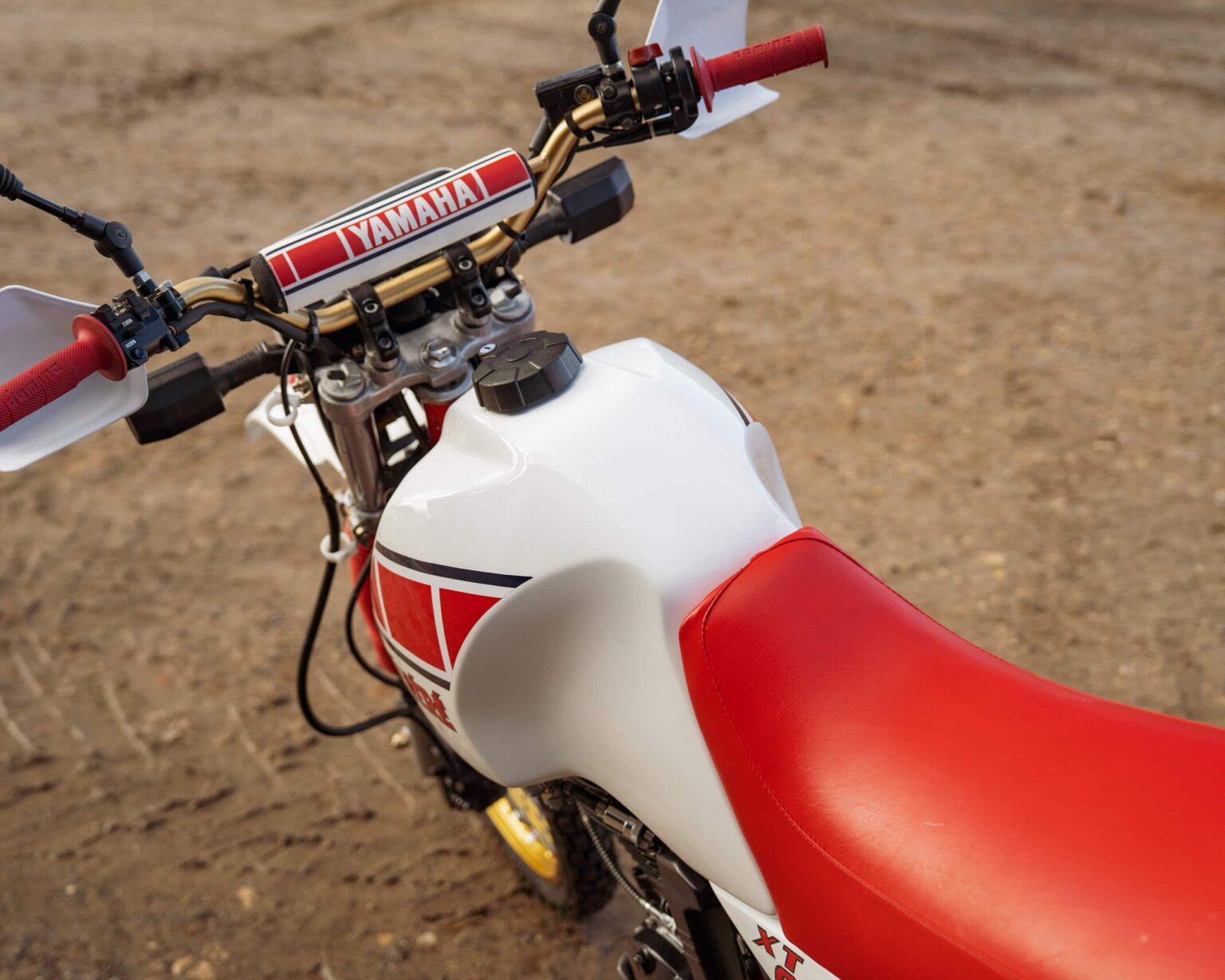 Yamaha dirt bike with red and white design, ready for motocross competition.