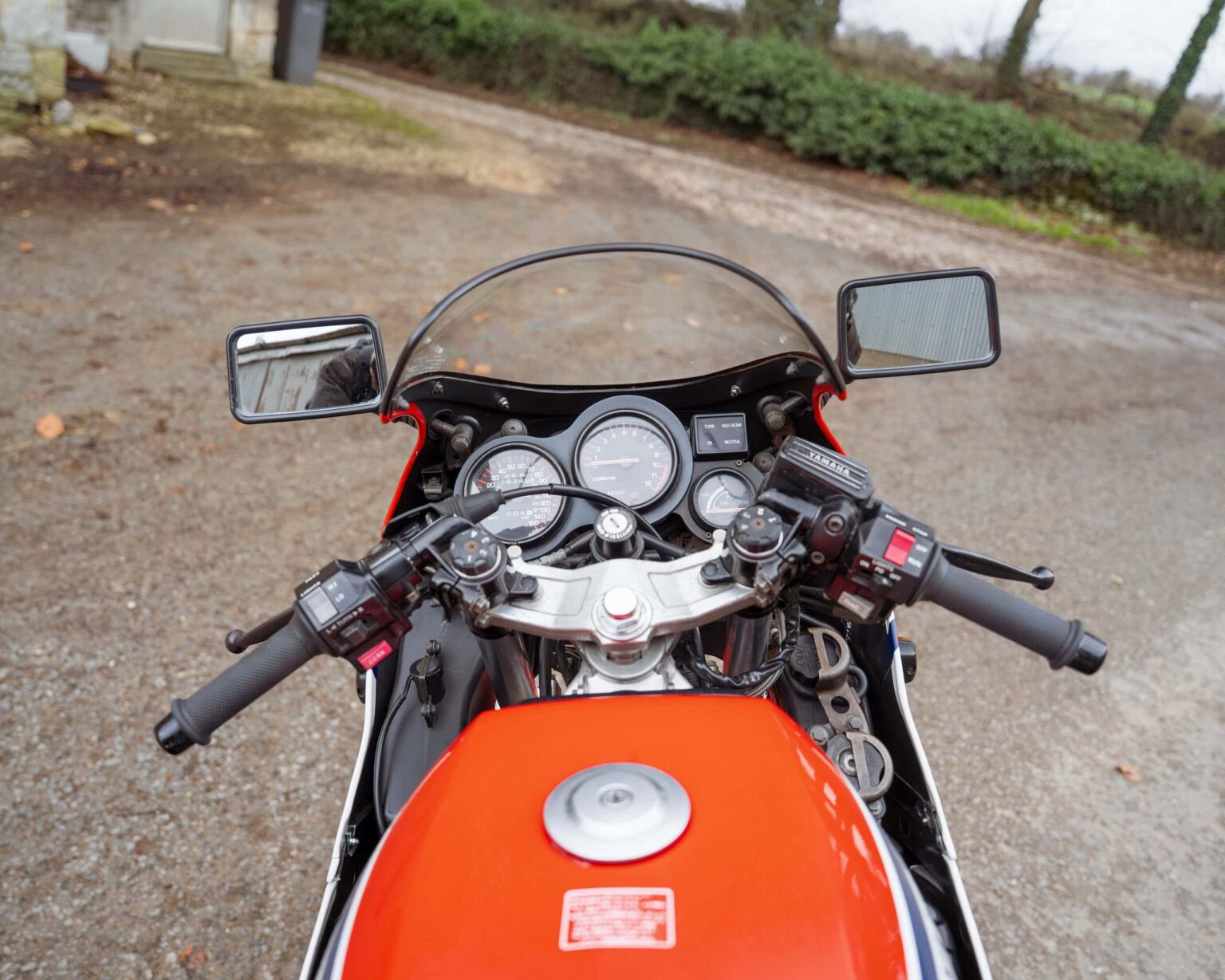 Motorcycle dashboard with speedometer, tachometer, and controls from the rider's perspective.