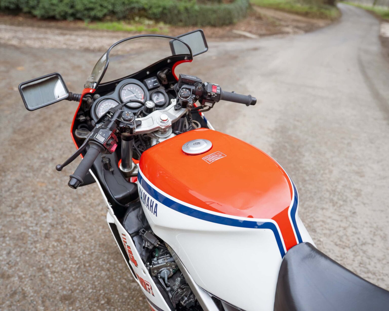 Yamaha vintage motorcycle with orange, white, and blue racing stripes.