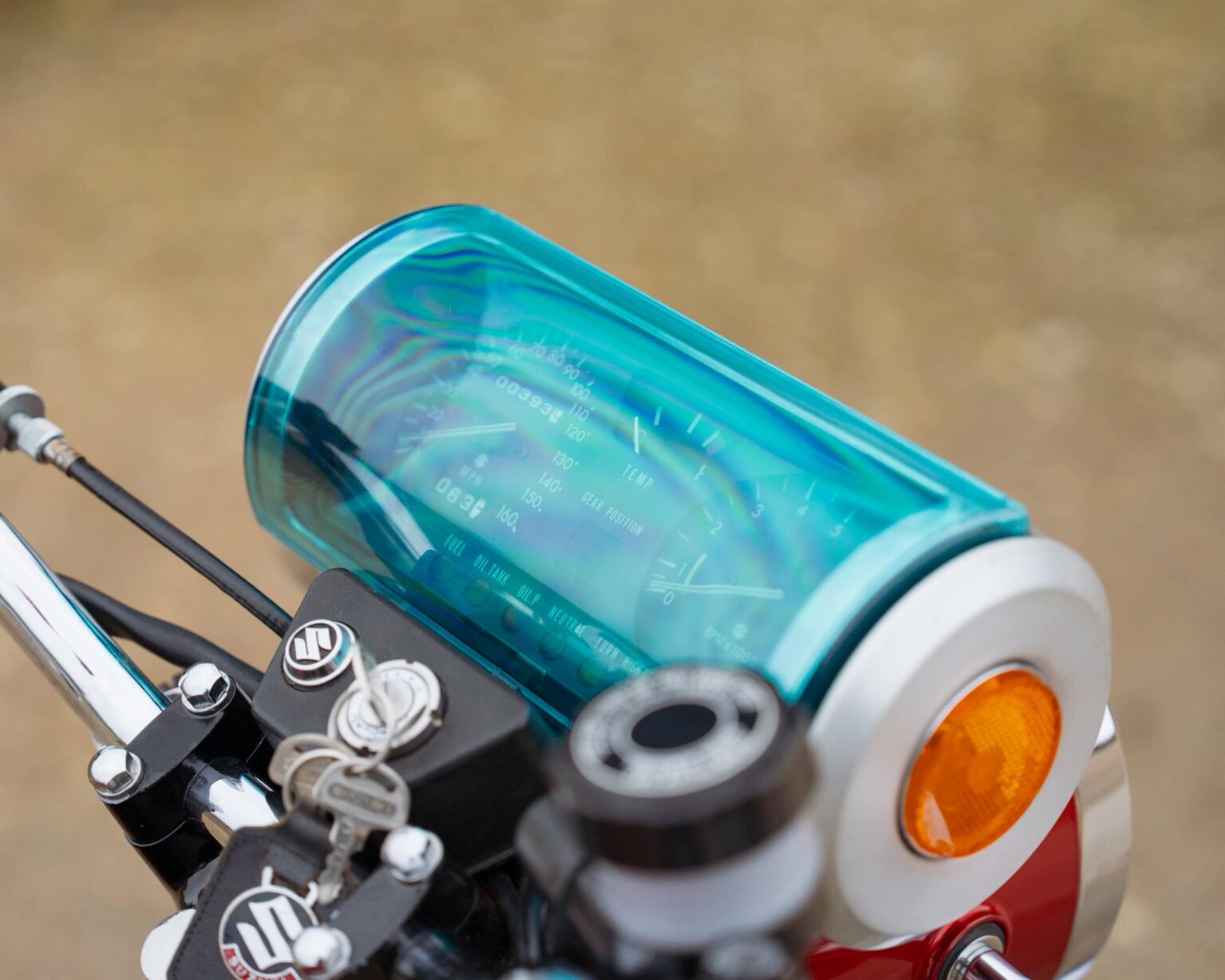 Motorcycle dashboard with digital display and blue protective cover.